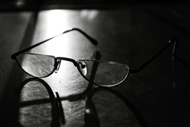 a pair of glasses sitting on top of a wooden table