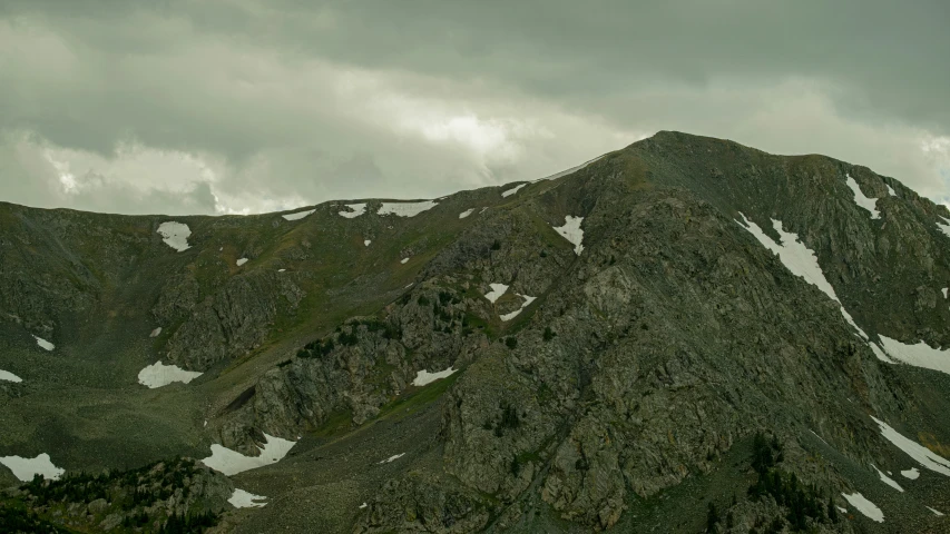 a tall mountain side with white snow on top