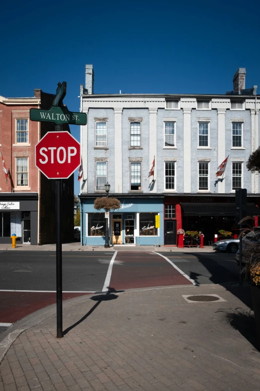 a stop sign sits in front of a street corner