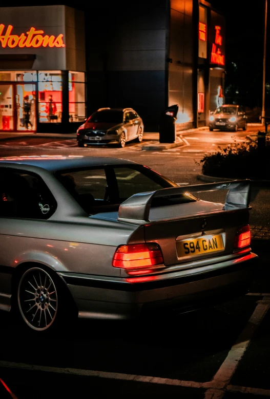 two cars sitting in the parking space of a store