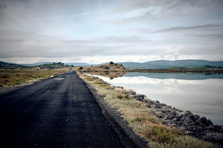 empty road leading to a large body of water