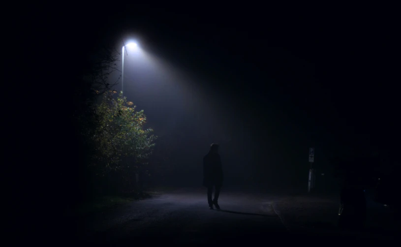 silhouette on road at night with streetlights