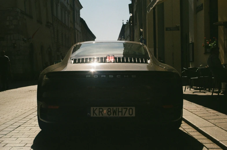 a car parked on a street with a person in a stroller behind it