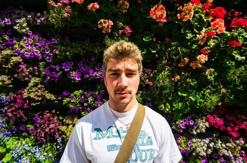 a man standing in front of some flowers