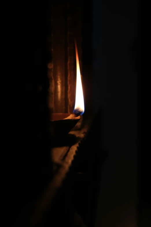 a candle burning on a wooden bench