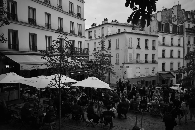 an outdoor market in a city, full of shops