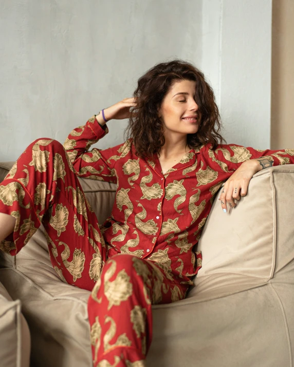 a woman sitting on a sofa in her pajamas