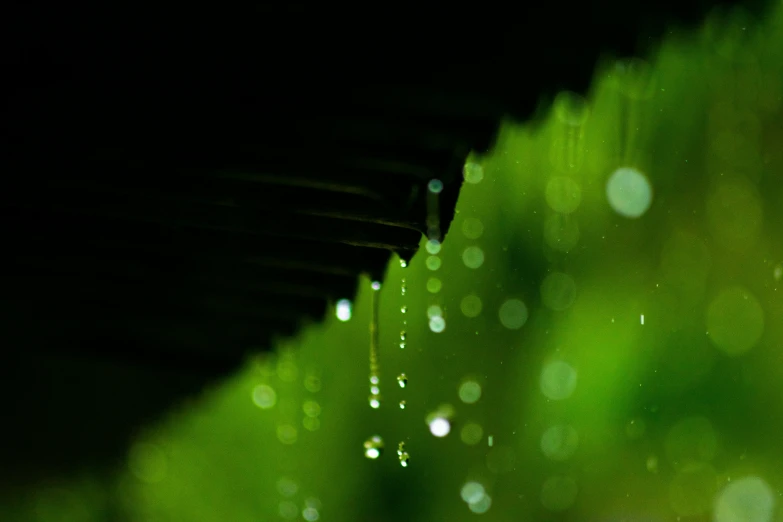 rain falling off the side of a roof in the dark