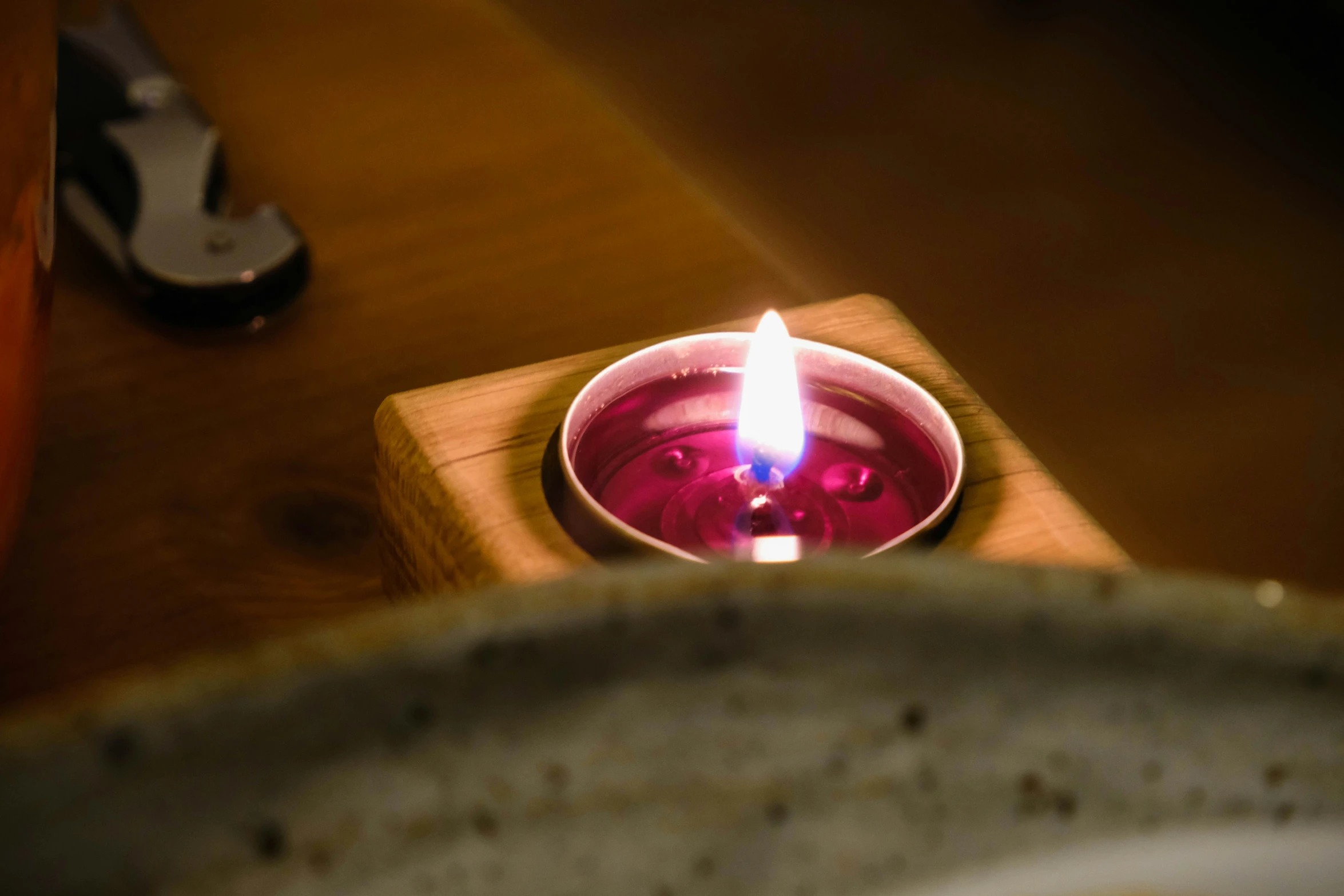 a tea light sits in a bowl on a wooden table