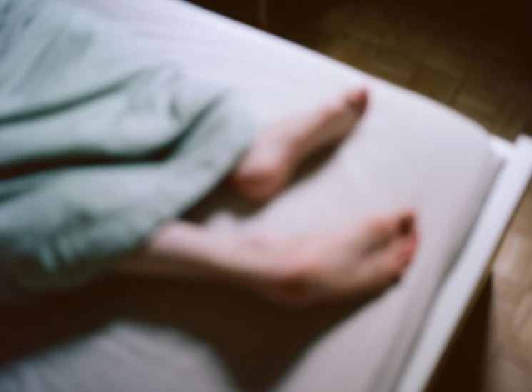 a person is on a bed with their foot on the floor