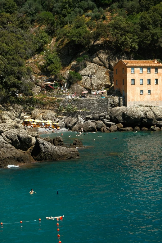 some people swimming in the ocean near rocks