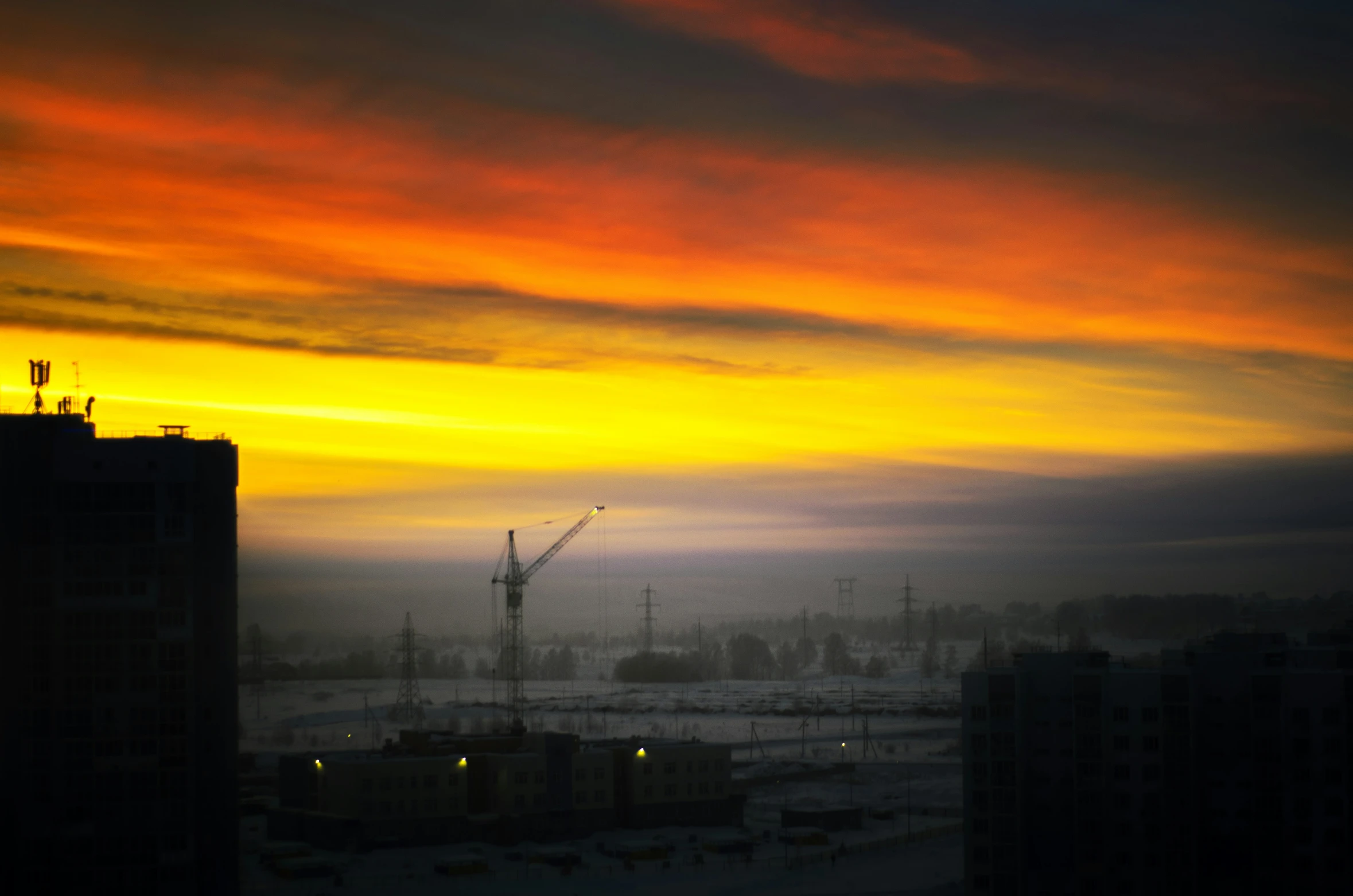 a colorful sunset over a snowy city landscape