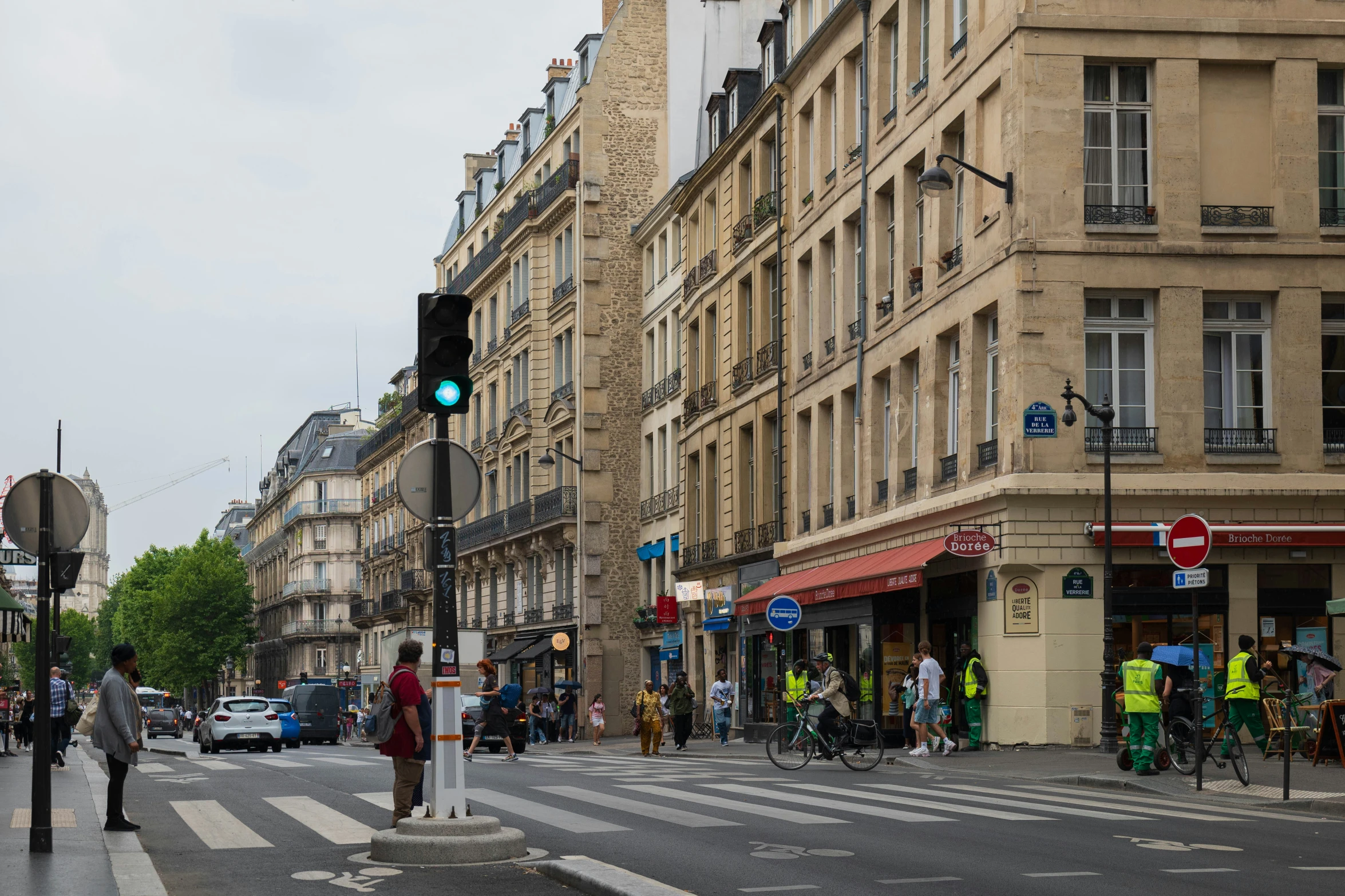 some pedestrians are on the street near buildings