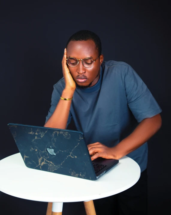 a man sitting at a desk using a laptop