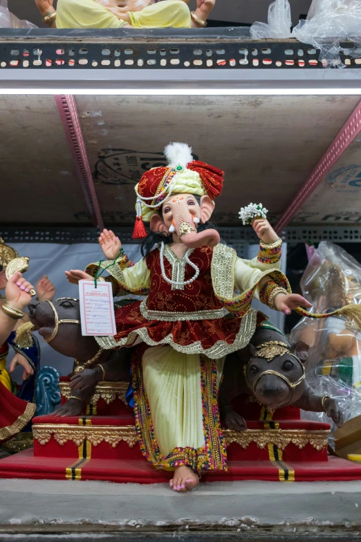 a statue of an elephant is performing with people sitting in the back