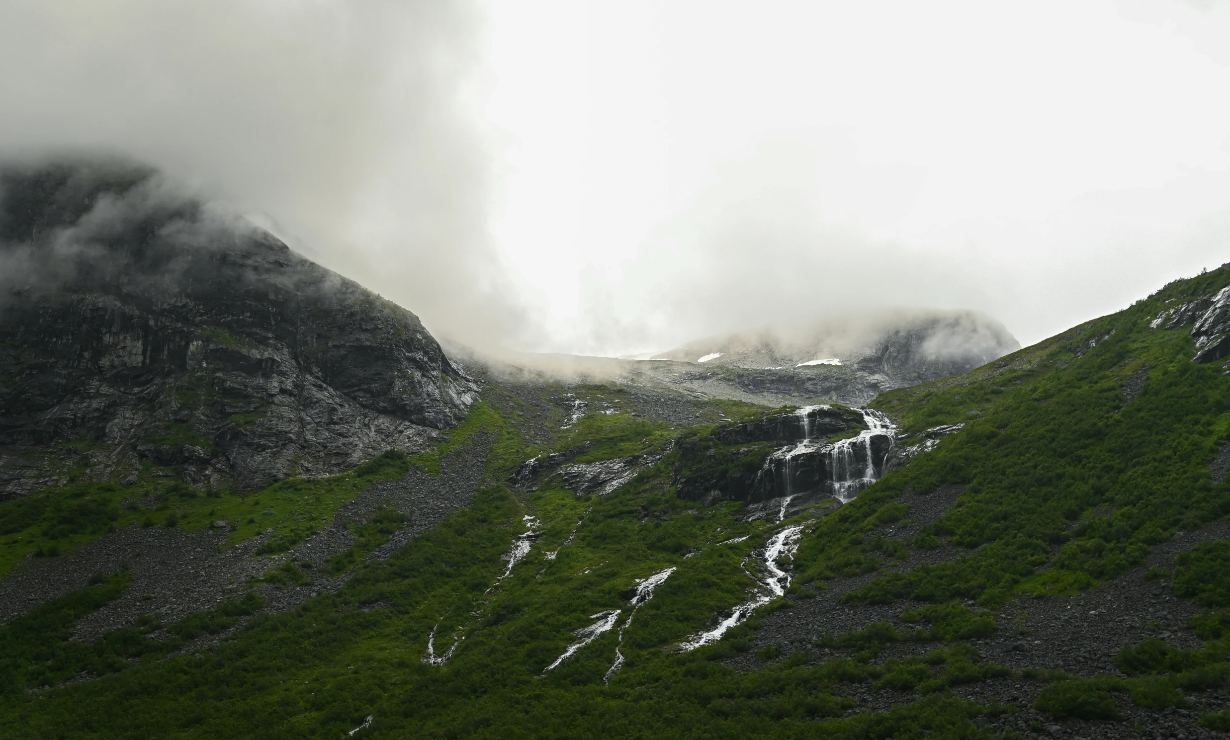 a very tall mountain with some clouds in the air