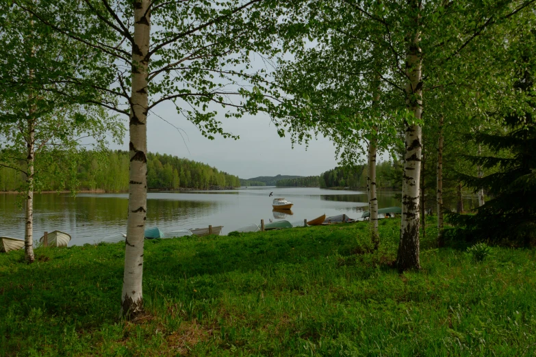 a small boat is in the lake on a cloudy day