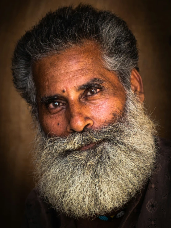 a man with a long white beard, wearing a black sweater