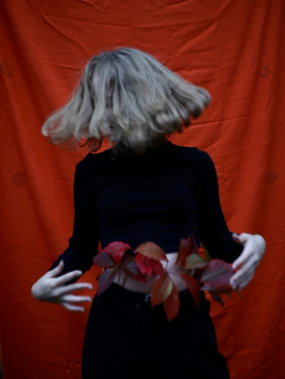 a woman with a bunch of leaves on her dress