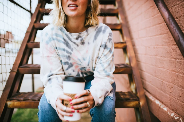 a beautiful blond woman holding a cup of coffee