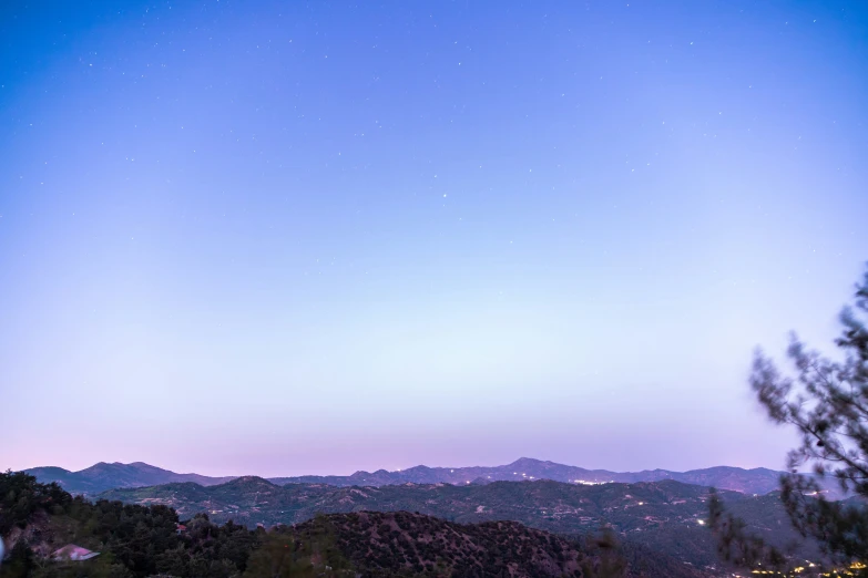 the night sky and a star filled mountain range in the background