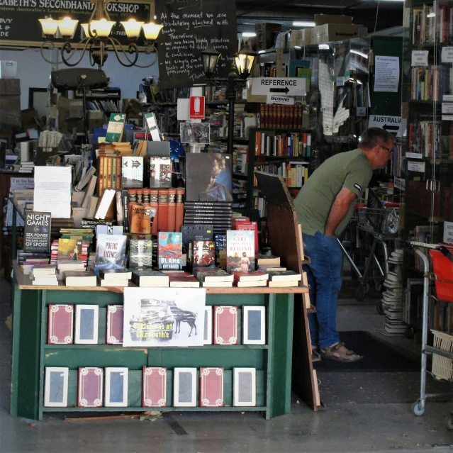 a man working inside of a shop surrounded by furniture