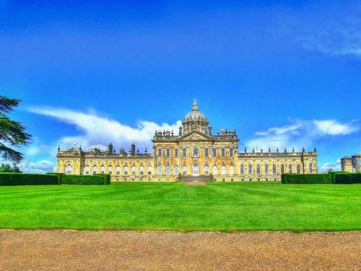 an ornate building with trees and lawn