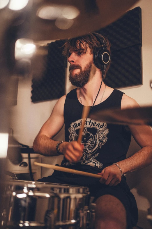 a man with ear phones playing on drums