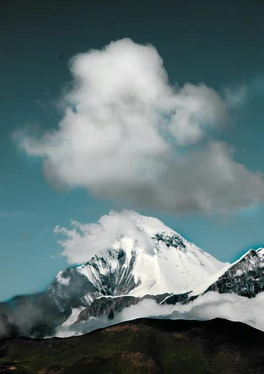 an alpine mountain under a cloudy sky