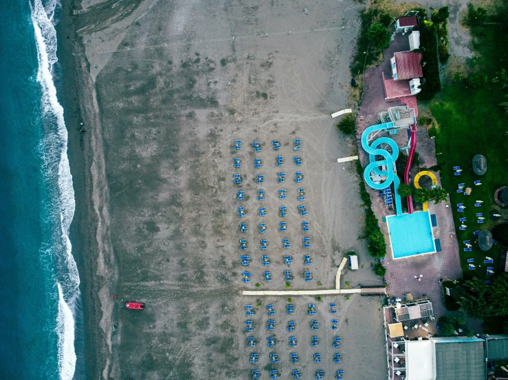 a large set of blue umbrellas and some chairs on a beach