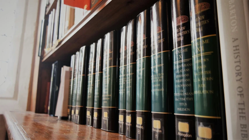 old books on a wooden shelf with white walls