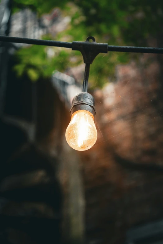 a light fixture on a wire outdoors on a sunny day