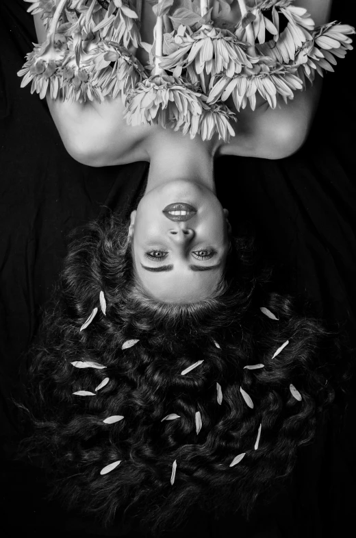 a woman has her face covered in grass, while lying on the ground