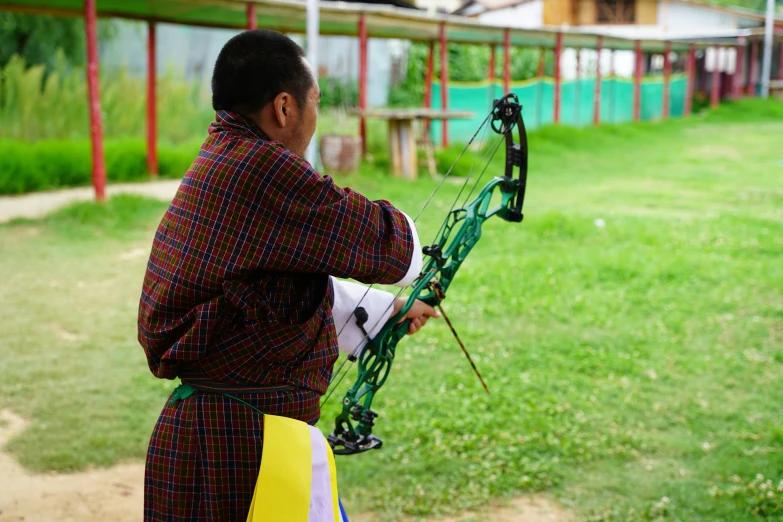 a man dressed in traditional clothes practicing his archery ss