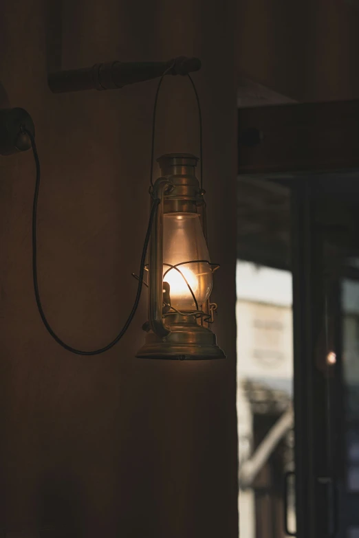 a candle shines from a small glass lamp fixture