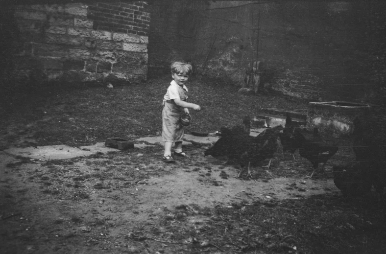 a small boy standing next to a firepit