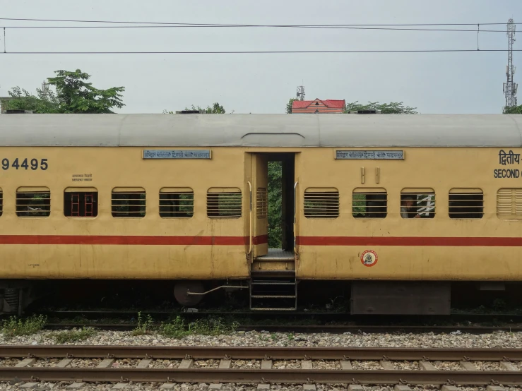 the train car is parked by the railroad tracks