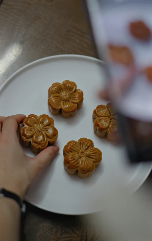 hand reaching for several small pastries on a plate