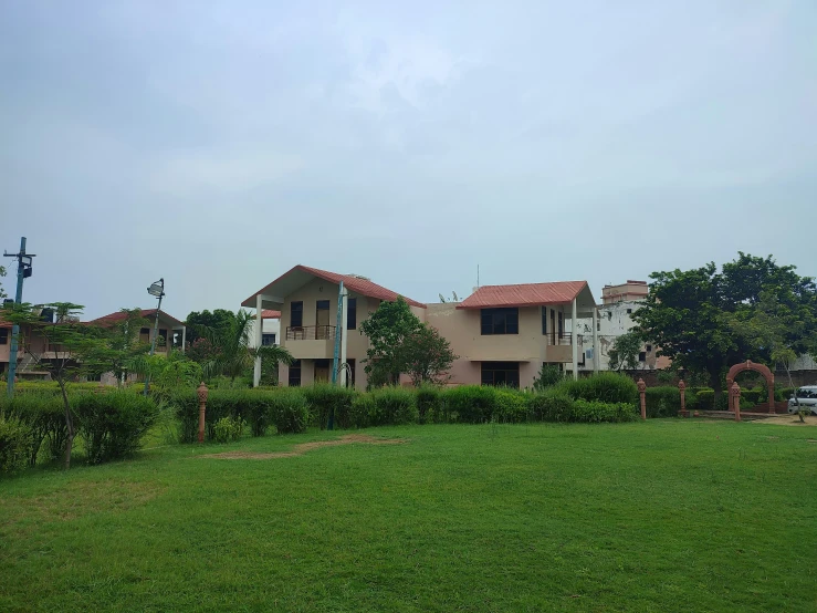 the grassy area in front of a house with red roof