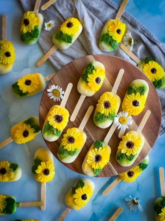 a pan of sunflowers are next to pops and skewers