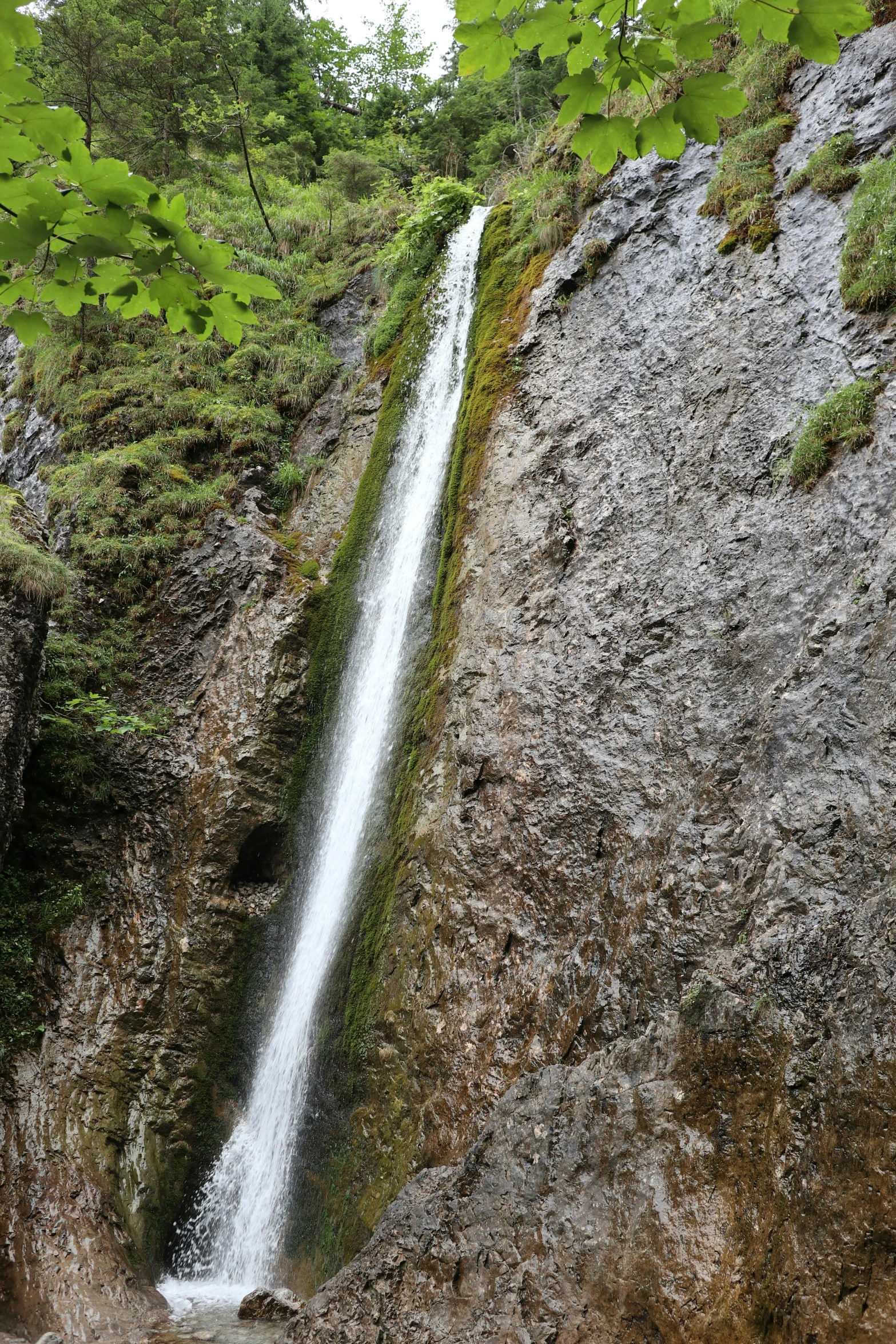 a waterfall is pouring water over the rocky cliffs