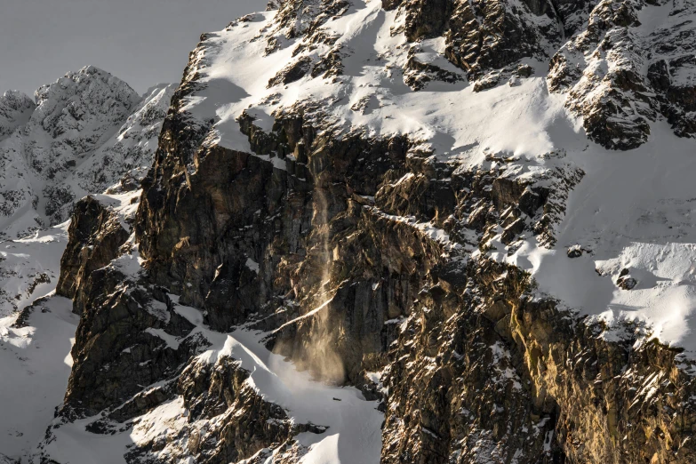 mountain with very tall rock structures, surrounded by snow