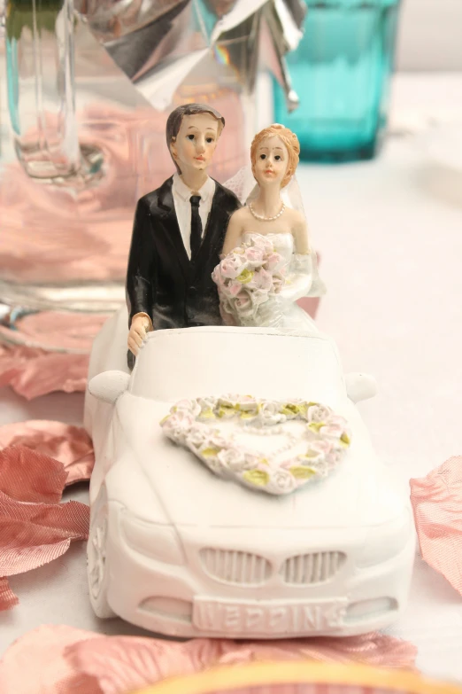 a couple in wedding attire sitting on their wedding car