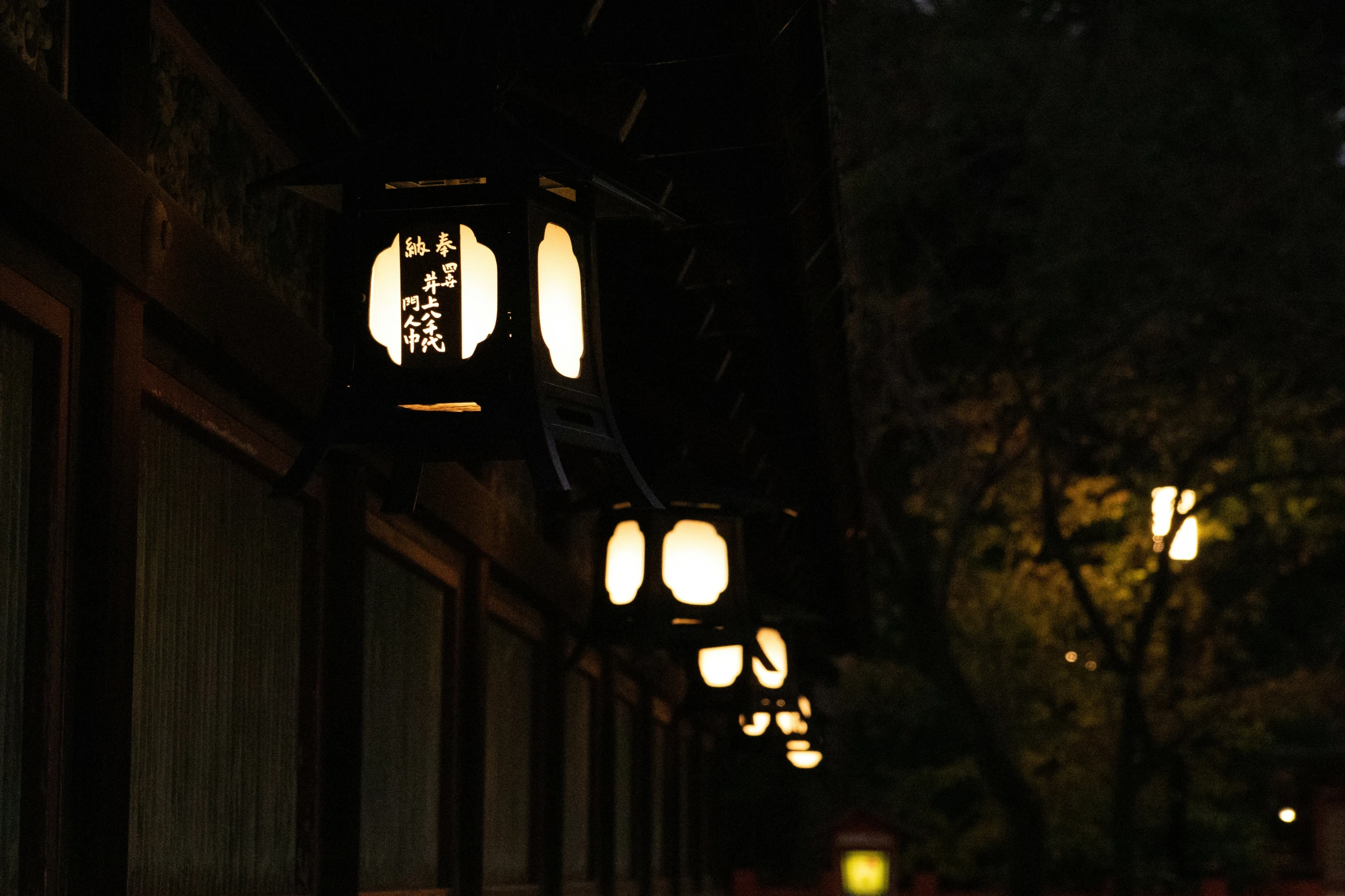 two light bulbs on an outdoor sidewalk next to a building