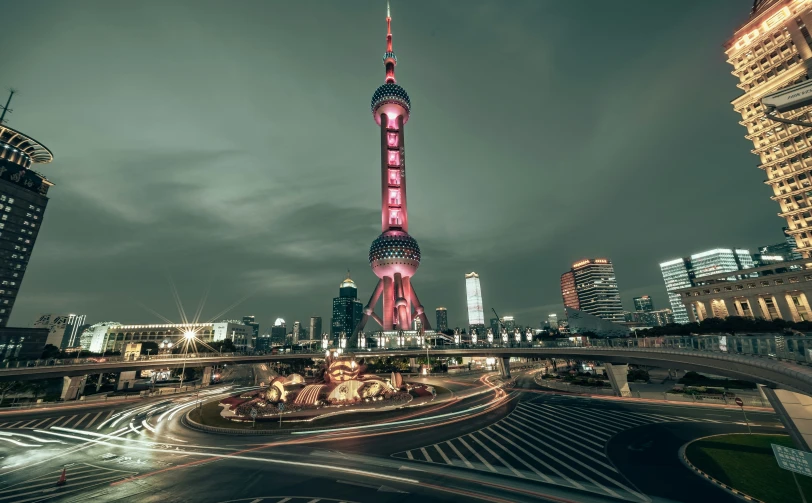 a city at night with a large building in the foreground and tall buildings in the background