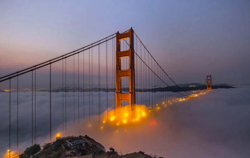 the golden gate bridge is lit up at night