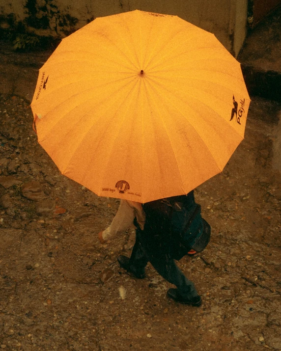 a person holding a large orange umbrella