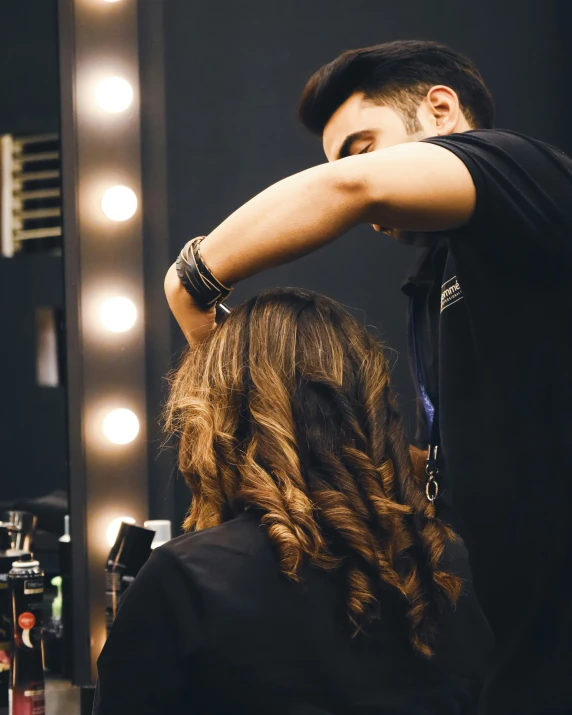 man doing hair styling in front of mirror