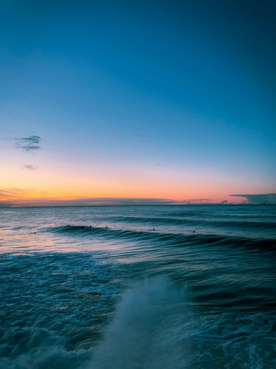 the sun is setting over a beach with some waves