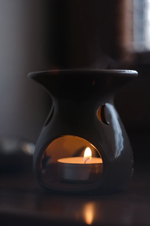 a candle lit sitting inside of a ceramic cup